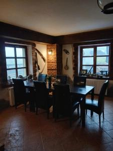 a dining room with a table and chairs and windows at Cabana Saua Diham in Paraul Rece