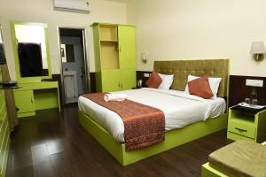 a bedroom with a large bed and a television at valparai home STAY LLHS in Vālpārai