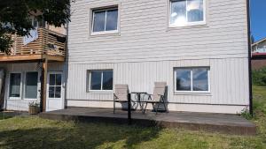 two chairs and a table in front of a house at Small cosy and fully equipped apartment with the possibility to rent a car in Tromsø