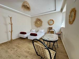 a room with a bed and a table and chairs at Maison Mira in Rabat