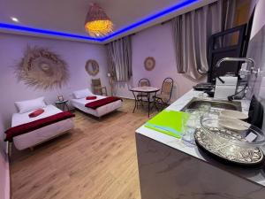 a room with two beds and a kitchen with a sink at Maison Mira in Rabat