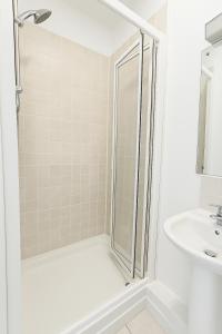 a white bathroom with a shower and a sink at Guinness and Grafton city stay in Dublin +1 photo