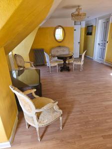 a room with chairs and a table and yellow walls at Solvang in Assens