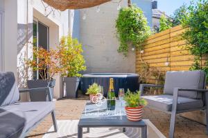 eine Terrasse mit einem Tisch und einer Flasche Champagner in der Unterkunft Havre de paix avec jacuzzi - Hyper-centre du Mans in Le Mans + 9 Fotos