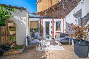 eine Terrasse mit zwei Stühlen und einem Tisch in der Unterkunft Havre de paix avec jacuzzi - Hyper-centre du Mans in Le Mans