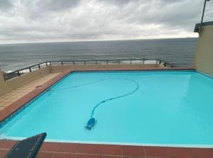 a swimming pool with the ocean in the background at Maya's Beachfront Haven in Westbrook