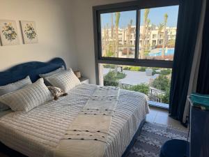 a bedroom with a bed and a large window at 4 Bedrooms Penthouse Villa, Marassi in El Alamein