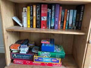 ein Bücherregal voller Bücher in der Unterkunft Little Hog Cottage, cosy seaside hideaway in Seaton