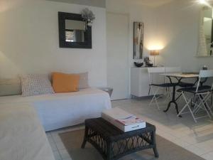 a living room with a bed and a table in it at Acapulco Frejus Plage in Fréjus