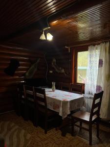 a dining room with a table and chairs and a window at Дім-Садиба Озерел in Krasna