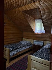 two beds in a room with a attic at Дім-Садиба Озерел in Krasna +25 photos