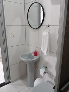a bathroom with a sink and a mirror and a toilet at Casa Blumenau in Blumenau