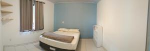 a small room with a bed and a window at Casa Blumenau in Blumenau