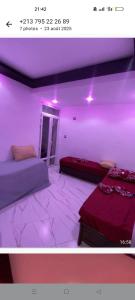 a room with two beds and purple lights in it at Saket plage in Bejaïa