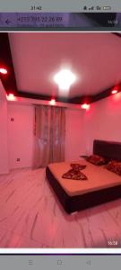 a room with two beds in a room with red lights at Saket plage in Bejaïa