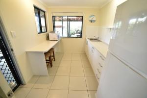 eine Küche mit weißen Arbeitsflächen und einem Waschbecken in der Unterkunft Rainbow Heights 2 Bed Apartment in Rainbow Beach + 11 Fotos