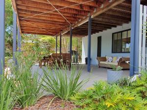 ein Haus mit einer Veranda mit einem Sofa und einer Terrasse in der Unterkunft Rainbow Heights 2 Bed Apartment in Rainbow Beach