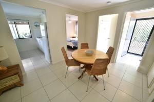 ein Esszimmer mit einem Holztisch und Stühlen in der Unterkunft Rainbow Heights 2 Bed Apartment in Rainbow Beach