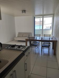 a kitchen with a stove and a table and chairs at Appartement à la mer in Saint-Hilaire-de-Riez