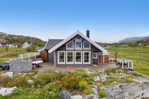 a house on the shore of a field at Hytte ved havet på Brensholmen, nær Sommarøy, Tromsø in Tromsø
