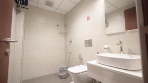 a white bathroom with a sink and a toilet at AS Suites in Cochin +17 photos