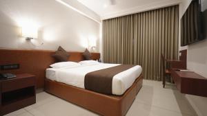 a hotel room with a bed and a desk at AS Suites in Cochin