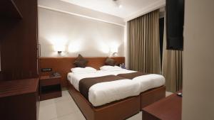 a bedroom with a large bed in a room at AS Suites in Cochin