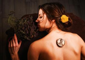a woman with a sticker on her back holding a bouquet of flowers at Folwark Łękuk in Łękuk Mały