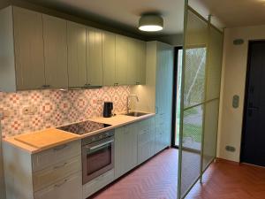 a kitchen with white cabinets and a stove top oven at Brzozowy Rożnów in Rożnów