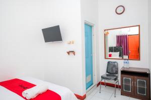 KaliangetにあるRedDoorz Syariah near Alun Alun Wonosobo 4のベッドと机と椅子のある寝室 +40枚の写真