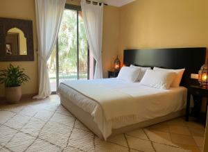 Ένα ή περισσότερα κρεβάτια σε δωμάτιο στο La perle de la palmeraie