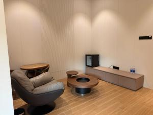 a living room with a chair and a table at Tambuna Retreat ,TAMBUN ,IPOH in Tambun +2 photos