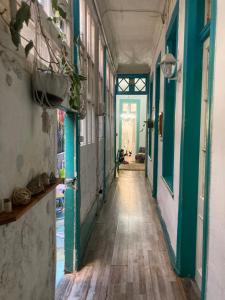 an empty hallway in a building with green walls and wooden floors at Don Ponchó in Valparaíso