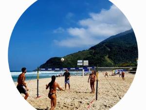 a group of people playing a game of volleyball on a beach at Apartamento Vista ao Mar Maresias in Maresias +61 photos