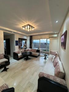 ein großes Wohnzimmer mit Sofas und einem Tisch in der Unterkunft Appartement Cosy Bord de Mer in Dar Mohammed Ould Haj Jilali