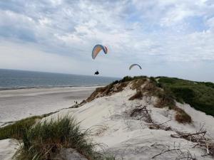 two people are flying kites on a beach at 4 person holiday home in Lemvig-By Traum in Trans