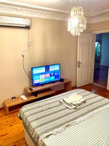 a living room with a tv and a bed at Şehrin merkezinde evinizde hissedeceğiniz oda in Konak
