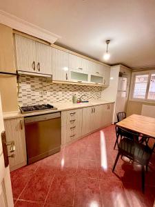 a kitchen with white cabinets and a table and a table and a tableablish at Şehrin merkezinde evinizde hissedeceğiniz oda in Konak