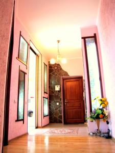 un pasillo con una puerta y un jarrón de flores en Guest House On Abdulliny Street 54 en Almaty