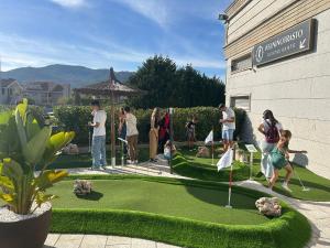a group of people standing around a putting green at Hotel Alfonso I in Tui
