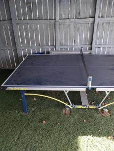 a ping pong table sitting in front of a fence at Le Monye in Lewisville