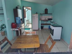 a kitchen with a wooden table and a refrigerator at KitnetPrado in Prado