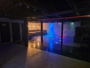 une pièce sombre avec une scène avec une lumière bleue dans l'établissement LoftHouseClub, à Varsovie