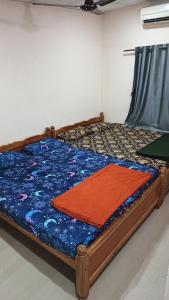 MalpeにあるRadhe Homestay Malpe Beach side, udupiの青い掛け布団が敷かれたベッドのある寝室