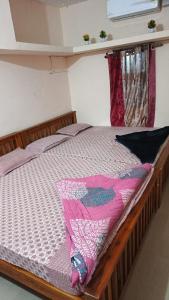 MalpeにあるRadhe Homestay Malpe Beach side, udupiのベッドルーム1室(木枠のベッド1台付)