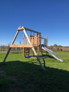 a wooden playground with a slide in a field at Chambres au cœur des vignes in Saint-Christoly-Médoc