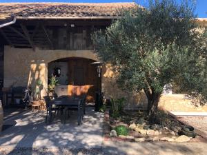a house with a table and a tree in front of it at Chambres au cœur des vignes in Saint-Christoly-Médoc