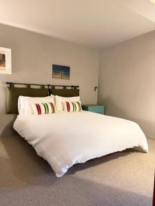 a bedroom with a large white bed with pillows at The Barns Low Stott Park near Lake Windermere in Ulverston