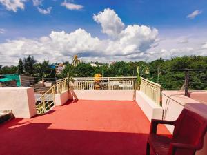 a balcony with a red floor and a white railing at Sumathi homestay in Hospet