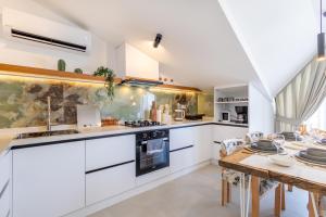 a kitchen with white cabinets and a dining table at Vera home in Marmaris